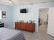 Bright bedroom with a dresser, wall-mounted TV, ceiling fan, and door leading to another room at 13779 Sw 115Th Cir, Dunnellon, FL 34432
