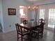 Dining room with view into the kitchen, wood table, chandelier, and natural light at 13779 Sw 115Th Cir, Dunnellon, FL 34432