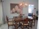 Cozy dining area featuring a wooden table, chandelier, and an open layout that connects to other living spaces at 13779 Sw 115Th Cir, Dunnellon, FL 34432