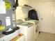 Efficient laundry area with a modern washer, dryer, utility shelving, and easy access to a nearby door at 13779 Sw 115Th Cir, Dunnellon, FL 34432