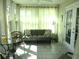 Bright sunroom with neutral colored sofa, tiled floor, and multiple windows at 13779 Sw 115Th Cir, Dunnellon, FL 34432