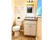 Well-lit bathroom features a toilet, vanity with a mirror, and a neutral color scheme at 1904 Ne 50Th St, Ocala, FL 34479
