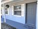 Close-up of the front door with a hanging flower basket and a decorative rug at 1904 Ne 50Th St, Ocala, FL 34479