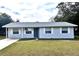Charming single story home with blue exterior, white trim and a well-maintained front yard at 1904 Ne 50Th St, Ocala, FL 34479