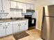 Galley style kitchen featuring white cabinets, stainless steel appliances and tile flooring at 1904 Ne 50Th St, Ocala, FL 34479