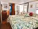 Spacious bedroom with a floral-patterned bedspread, wood-look floors, and natural light at 19390 Se 95Th Pl, Ocklawaha, FL 32179