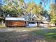 Exterior view of the home featuring a shed, screened in porch and mature trees at 19390 Se 95Th Pl, Ocklawaha, FL 32179