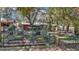 View of a red cottage with a well-maintained fenced-in garden area at 19390 Se 95Th Pl, Ocklawaha, FL 32179