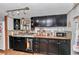 Functional kitchen featuring dark cabinets, neutral countertops, and tiled backsplash at 19390 Se 95Th Pl, Ocklawaha, FL 32179