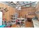 Spacious workshop area featuring wooden floors, exposed beams, and a variety of tools and equipment at 19390 Se 95Th Pl, Ocklawaha, FL 32179