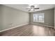 Bright bedroom with wood flooring, neutral walls, and a picture window providing natural light at 2 Hemlock Terrace Trl, Ocala, FL 34472