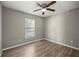 Neutral bedroom with wood-look floors, ceiling fan, and a window for natural light at 2 Hemlock Terrace Trl, Ocala, FL 34472