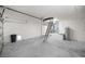 Spacious garage with concrete flooring, water heater, and ladder to attic at 2 Hemlock Terrace Trl, Ocala, FL 34472