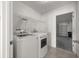 Bright laundry room with washer and dryer hookups and wire rack shelving for storage at 2 Hemlock Terrace Trl, Ocala, FL 34472