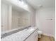 This bathroom features a light granite countertop, large mirror, white cabinets, and white walls and fixtures at 24264 Sw South Hills Ct, Dunnellon, FL 34431