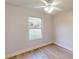 Cozy bedroom features wood-look flooring, a ceiling fan, and natural light from the window at 24264 Sw South Hills Ct, Dunnellon, FL 34431