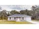 Charming single-story home with neutral paint, gray roof, attached garage and tidy landscaping at 24264 Sw South Hills Ct, Dunnellon, FL 34431