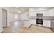Open-concept kitchen with white cabinets, granite countertops, stainless steel appliances, and vaulted ceiling at 24264 Sw South Hills Ct, Dunnellon, FL 34431
