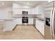 This kitchen features stainless steel appliances, granite countertops, and white cabinets with chrome hardware at 24264 Sw South Hills Ct, Dunnellon, FL 34431