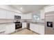 Updated kitchen with stainless steel appliances, granite countertops, and white cabinets at 24264 Sw South Hills Ct, Dunnellon, FL 34431