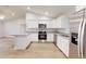 Spacious kitchen features white cabinetry, stainless steel appliances, granite countertops, and wood flooring at 24264 Sw South Hills Ct, Dunnellon, FL 34431