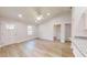 This living room has light wood flooring, neutral walls, a ceiling fan, and a white front door at 24264 Sw South Hills Ct, Dunnellon, FL 34431