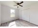 Bright bedroom featuring a ceiling fan, gray laminate flooring, and a double door closet at 3372 Se 144Th Pl, Summerfield, FL 34491