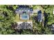 An aerial view of the home, pool, garden, and surrounding trees at 4940 E Fort King St, Ocala, FL 34470