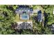 Aerial view showcases a screened pool and spa, manicured gardens, and an additional building on a private lot at 4940 E Fort King St, Ocala, FL 34470