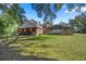 Expansive backyard featuring a screened pool, brick home, and a black metal fence at 4940 E Fort King St, Ocala, FL 34470