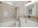 Cozy bathroom with tub/shower combo, white vanity and commode, and marble-look tile at 4940 E Fort King St, Ocala, FL 34470