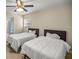 Bright bedroom with two twin beds, ceiling fan, and an ensuite bathroom at 4940 E Fort King St, Ocala, FL 34470