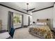 Bright bedroom with large windows, dark trim, and a stylish ceiling fan at 4940 E Fort King St, Ocala, FL 34470