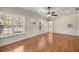A well-lit bonus room with hardwood floors, wainscoting, large windows, and a ceiling fan at 4940 E Fort King St, Ocala, FL 34470