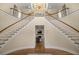 Grand foyer with a split staircase, hardwood floors, elegant chandelier, and views into the living room at 4940 E Fort King St, Ocala, FL 34470