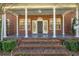 Inviting brick home featuring a covered front porch with stately white columns and classic front door with sidelights at 4940 E Fort King St, Ocala, FL 34470