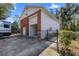 Large garage with both a rollup bay door and regular door, surrounded by a black fence at 4940 E Fort King St, Ocala, FL 34470