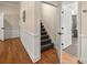 Inviting hallway with hardwood floors, leading to a staircase and a glimpse of a modern bathroom at 4940 E Fort King St, Ocala, FL 34470