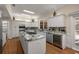 A large white kitchen features an island cooktop, granite counters, and stainless steel appliances at 4940 E Fort King St, Ocala, FL 34470