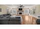 Bright living room with hardwood floors, stone fireplace, and comfortable gray sectional at 4940 E Fort King St, Ocala, FL 34470