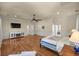 Spacious main bedroom with hardwood floors, ceiling fan, and a glimpse of the en suite bathroom at 4940 E Fort King St, Ocala, FL 34470