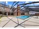 Large in-ground pool surrounded by a screened enclosure, brick home and spacious patio at 4940 E Fort King St, Ocala, FL 34470