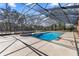 A luxurious screened pool with a connected spa and ample space for relaxation and entertainment at 4940 E Fort King St, Ocala, FL 34470