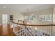Elegant staircase featuring hardwood steps, white railings, and a stunning chandelier, with lots of natural light at 4940 E Fort King St, Ocala, FL 34470