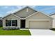 Charming single-story home featuring a two-car garage, well-manicured lawn, and colorful flowering tree at 7136 Se 113Th Ln, Belleview, FL 34420