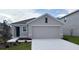 Charming single-story home featuring a two-car garage, neutral color palette, and well-maintained landscaping at 8470 Las Palmas Way, Wildwood, FL 34785