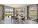 Dining area with a modern table set, backyard views, and stylish curtains at 8474 Las Palmas Way, Wildwood, FL 34785