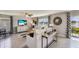 Bright living room with pond views, modern decor, and access to outdoor seating at 8474 Las Palmas Way, Wildwood, FL 34785