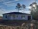 Charming single-story home featuring a classic design, light gray siding, and large windows at 1 Fisher Lane Way, Ocklawaha, FL 32179