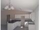 Bright kitchen with white cabinets, black countertops, island and modern lighting, enhancing style and functionality at 1 Fisher Lane Way, Ocklawaha, FL 32179